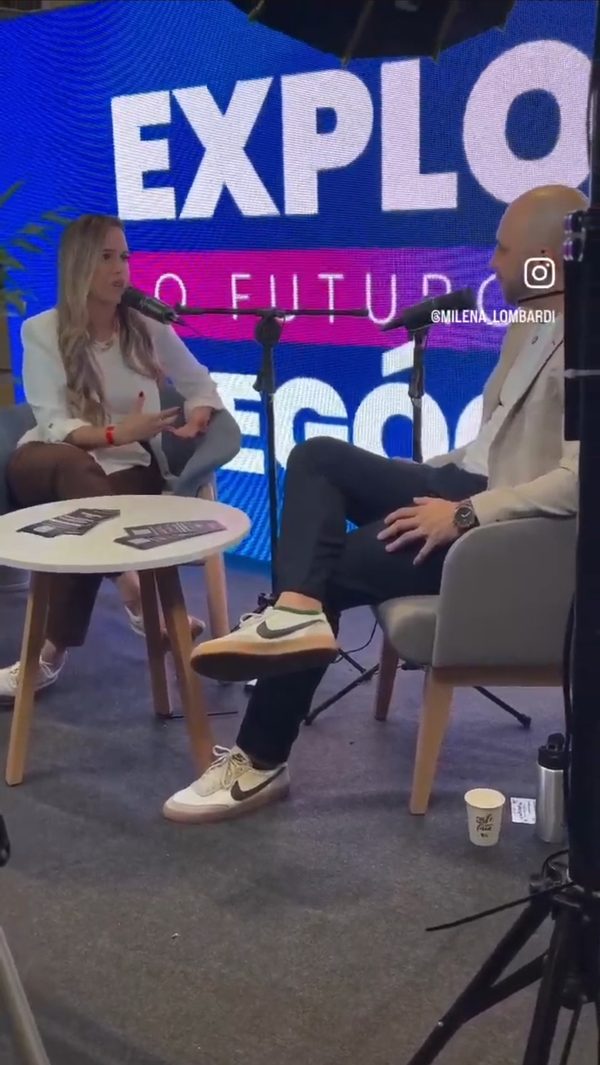 Milena dando entrevista em um podcast, em um evento de negócios